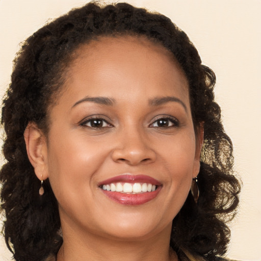 Joyful black young-adult female with long  brown hair and brown eyes