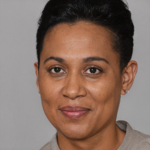 Joyful black adult female with short  black hair and brown eyes