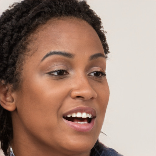 Joyful black young-adult female with long  brown hair and brown eyes