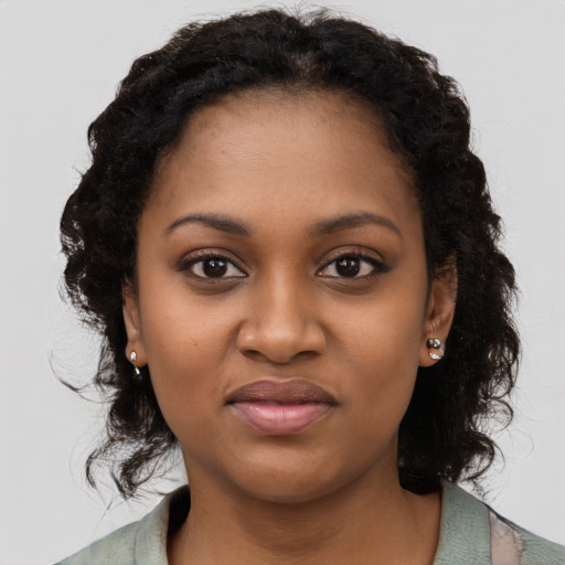 Joyful black young-adult female with long  brown hair and brown eyes