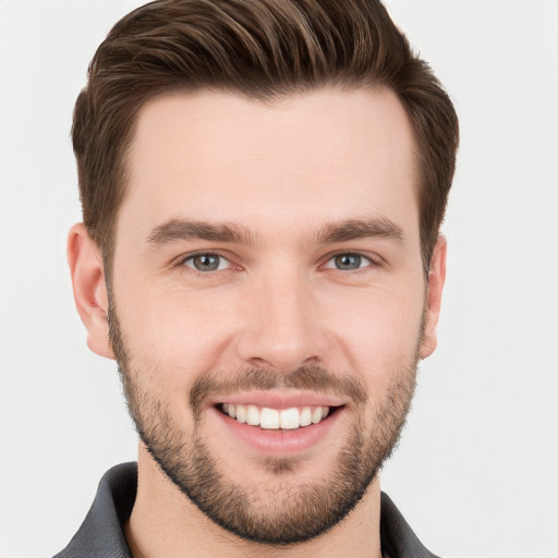 Joyful white young-adult male with short  brown hair and grey eyes