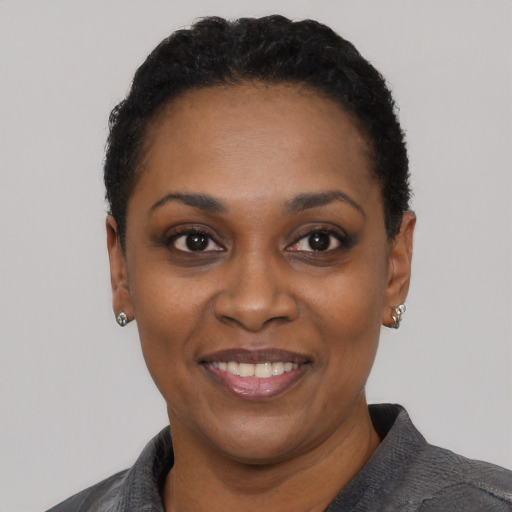 Joyful black adult female with short  black hair and brown eyes