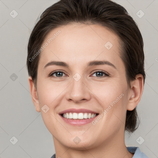 Joyful white young-adult female with medium  brown hair and grey eyes