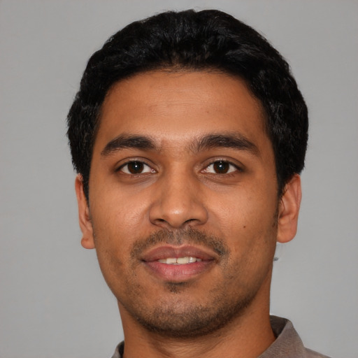 Joyful latino young-adult male with short  black hair and brown eyes