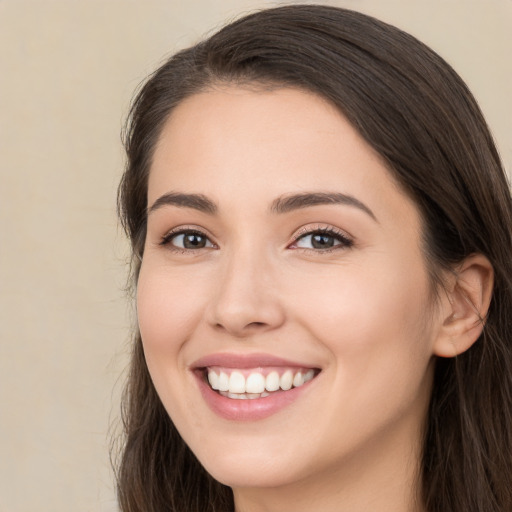 Joyful white young-adult female with long  brown hair and brown eyes