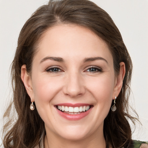 Joyful white young-adult female with long  brown hair and grey eyes