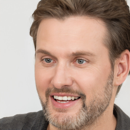 Joyful white adult male with short  brown hair and brown eyes