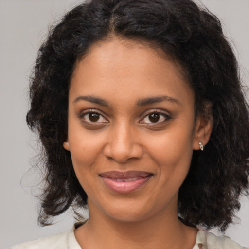Joyful black young-adult female with medium  brown hair and brown eyes