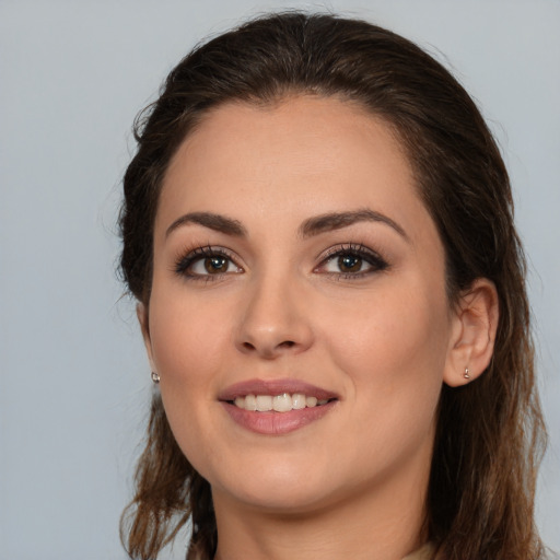 Joyful white young-adult female with long  brown hair and brown eyes