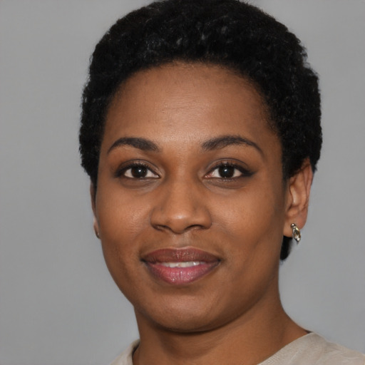 Joyful black young-adult female with short  black hair and brown eyes