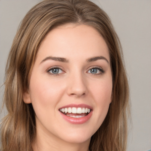 Joyful white young-adult female with long  brown hair and grey eyes