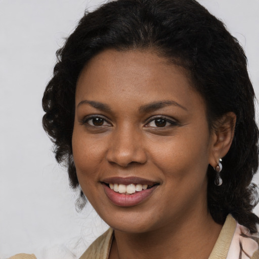 Joyful black young-adult female with long  brown hair and brown eyes