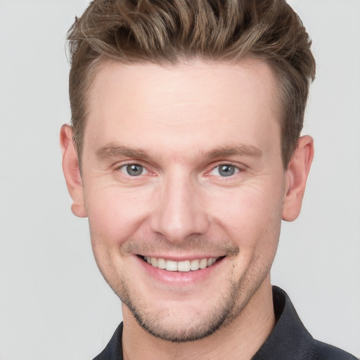 Joyful white young-adult male with short  brown hair and grey eyes