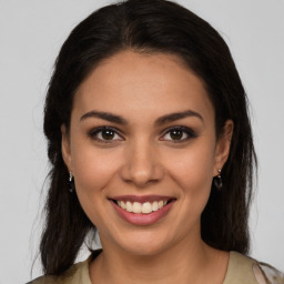 Joyful latino young-adult female with long  brown hair and brown eyes