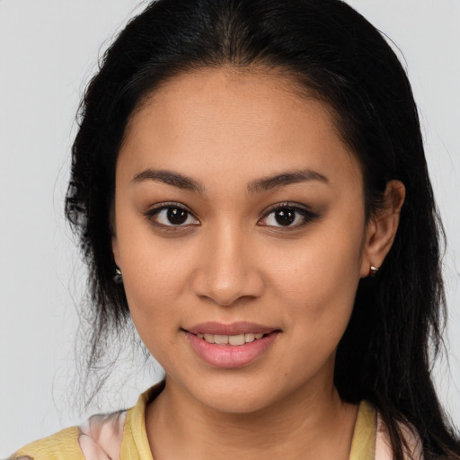 Joyful latino young-adult female with long  brown hair and brown eyes