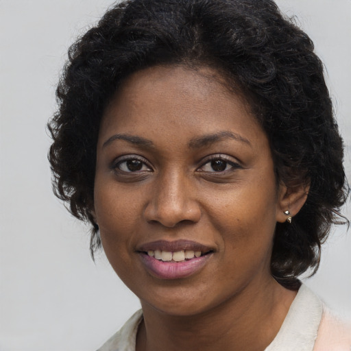 Joyful black young-adult female with medium  brown hair and brown eyes