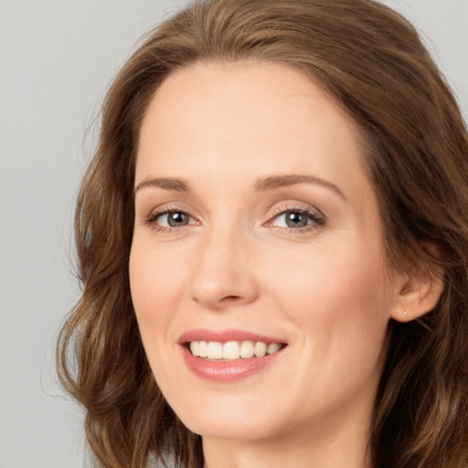 Joyful white young-adult female with long  brown hair and green eyes