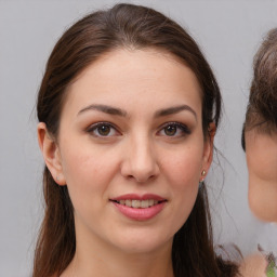 Joyful white young-adult female with medium  brown hair and brown eyes