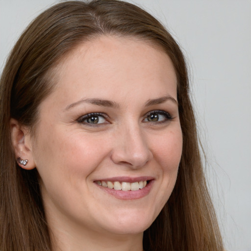 Joyful white young-adult female with long  brown hair and grey eyes