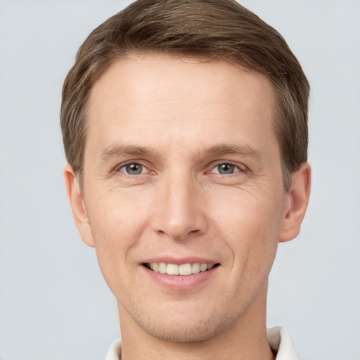 Joyful white young-adult male with short  brown hair and grey eyes