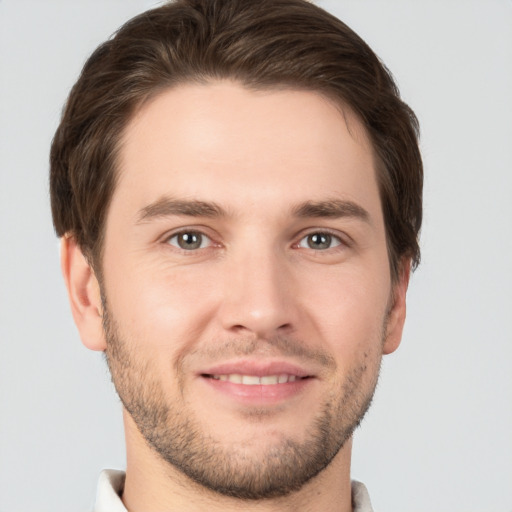 Joyful white young-adult male with short  brown hair and grey eyes