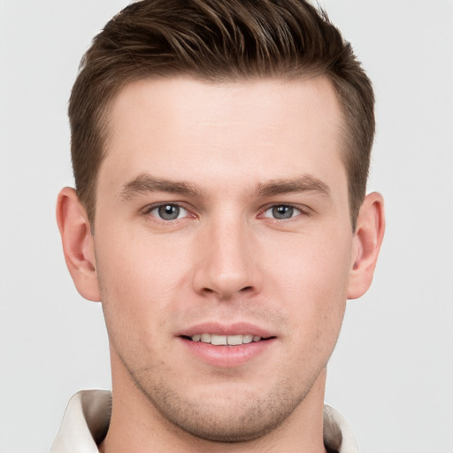 Joyful white young-adult male with short  brown hair and grey eyes