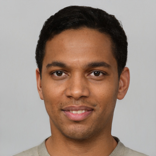 Joyful black young-adult male with short  black hair and brown eyes