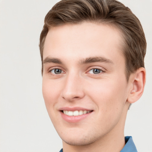 Joyful white young-adult male with short  brown hair and grey eyes