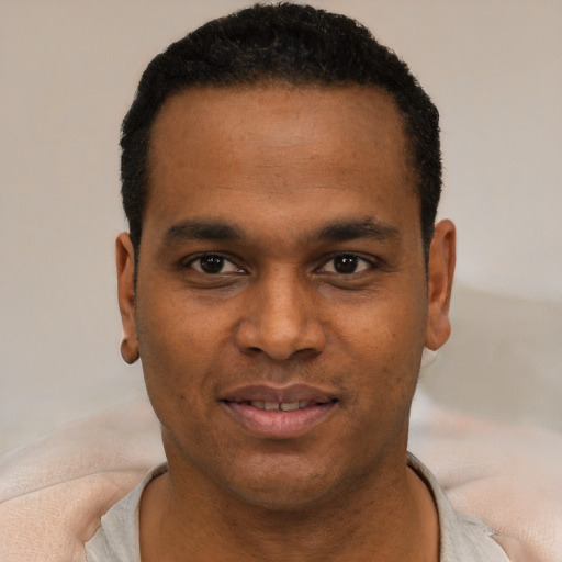 Joyful black young-adult male with short  black hair and brown eyes