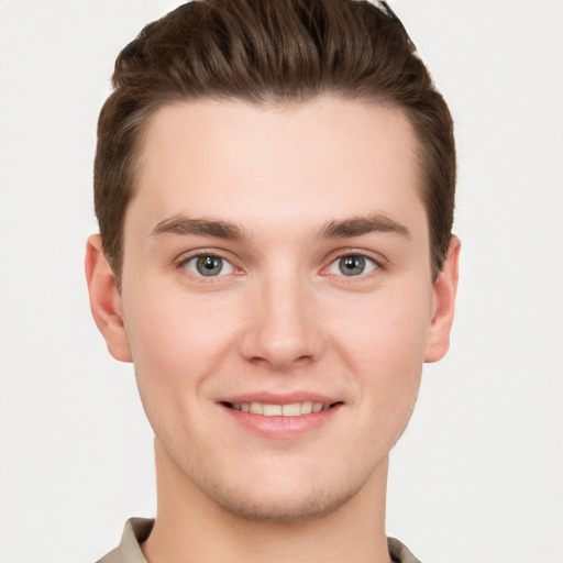 Joyful white young-adult male with short  brown hair and grey eyes