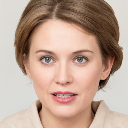 Joyful white young-adult female with medium  brown hair and grey eyes