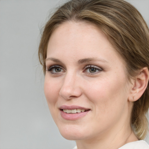 Joyful white young-adult female with medium  brown hair and blue eyes