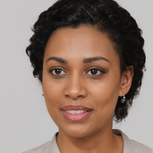Joyful black young-adult female with short  black hair and brown eyes