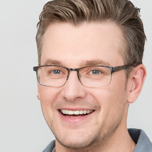 Joyful white adult male with short  brown hair and blue eyes