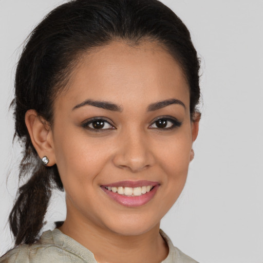 Joyful latino young-adult female with medium  brown hair and brown eyes