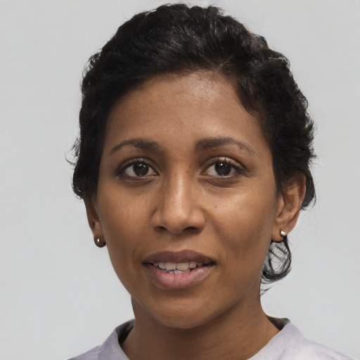 Joyful black adult female with short  black hair and brown eyes