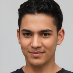 Joyful latino young-adult male with short  brown hair and brown eyes