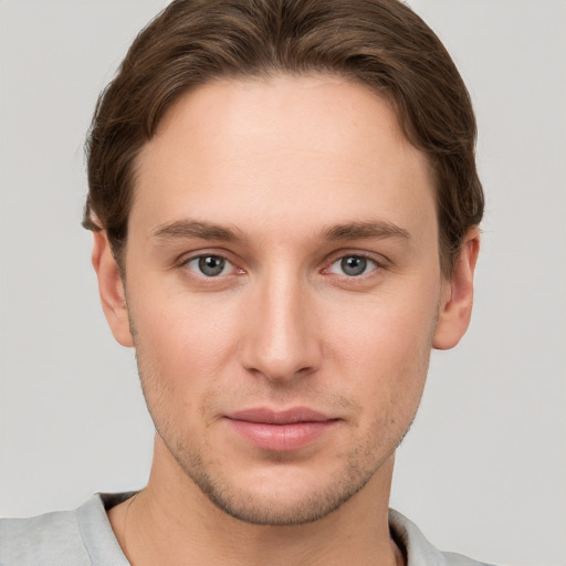 Joyful white young-adult male with short  brown hair and grey eyes