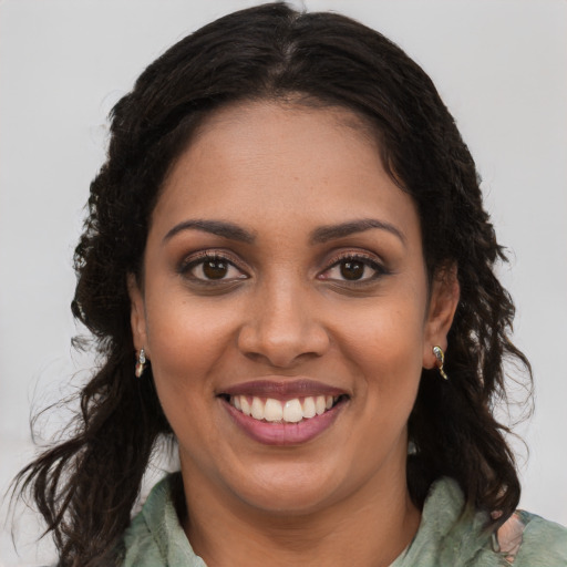 Joyful black young-adult female with long  brown hair and brown eyes