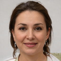 Joyful white adult female with medium  brown hair and brown eyes