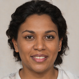 Joyful black adult female with medium  brown hair and brown eyes