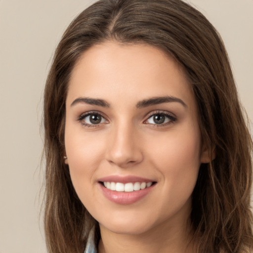 Joyful white young-adult female with long  brown hair and brown eyes