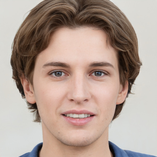 Joyful white young-adult male with medium  brown hair and grey eyes