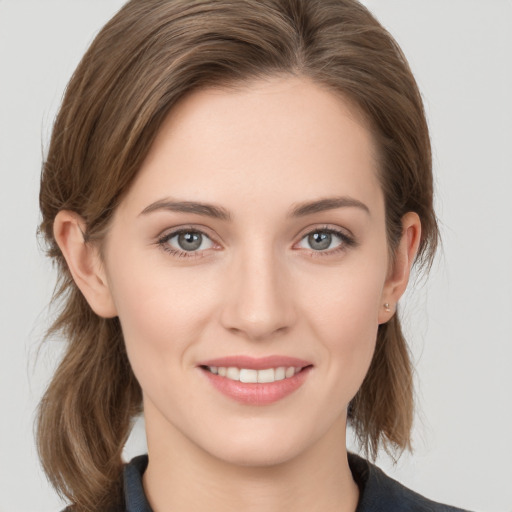 Joyful white young-adult female with medium  brown hair and grey eyes