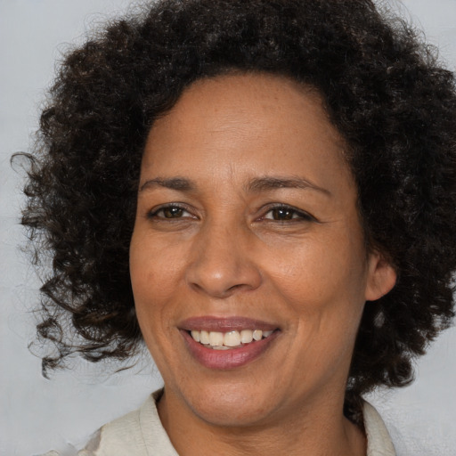 Joyful black adult female with medium  brown hair and brown eyes
