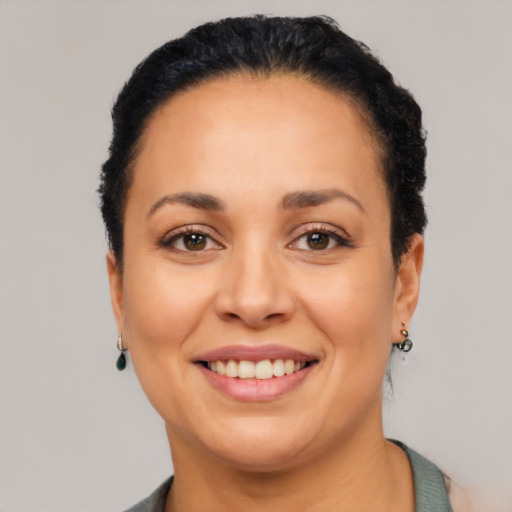 Joyful latino young-adult female with short  black hair and brown eyes