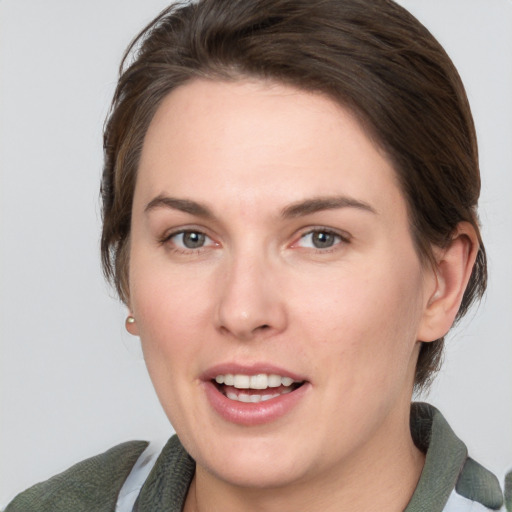 Joyful white young-adult female with medium  brown hair and grey eyes