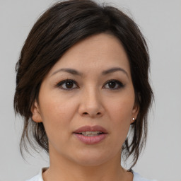 Joyful asian adult female with medium  brown hair and brown eyes