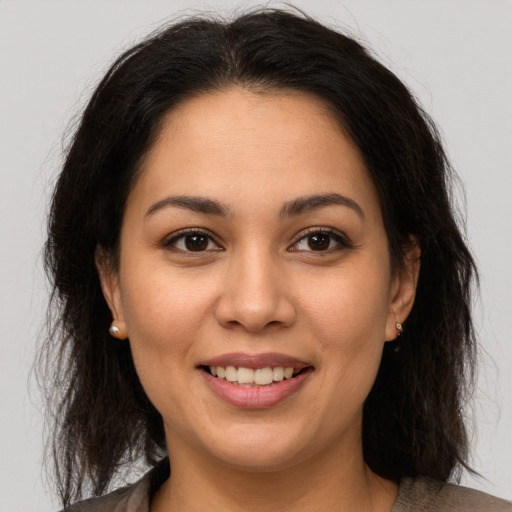 Joyful latino young-adult female with long  brown hair and brown eyes