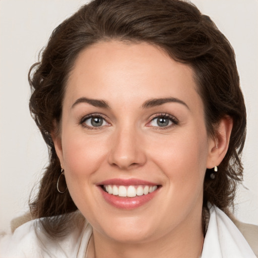 Joyful white young-adult female with medium  brown hair and green eyes